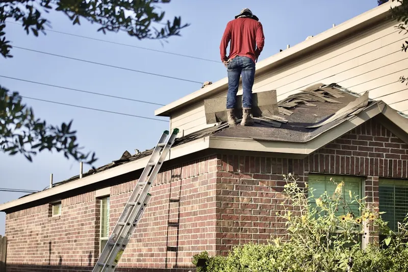 Professional roofer working on a residential roof in Wolcott